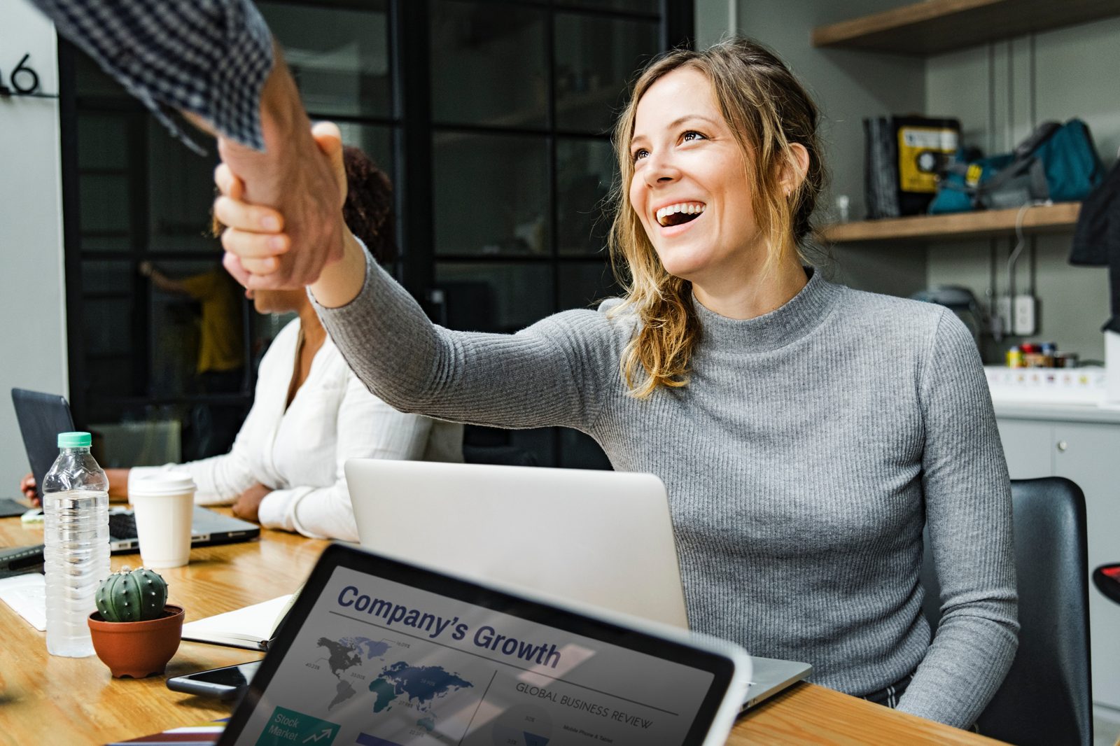 Smiling customer shaking hands across a desk